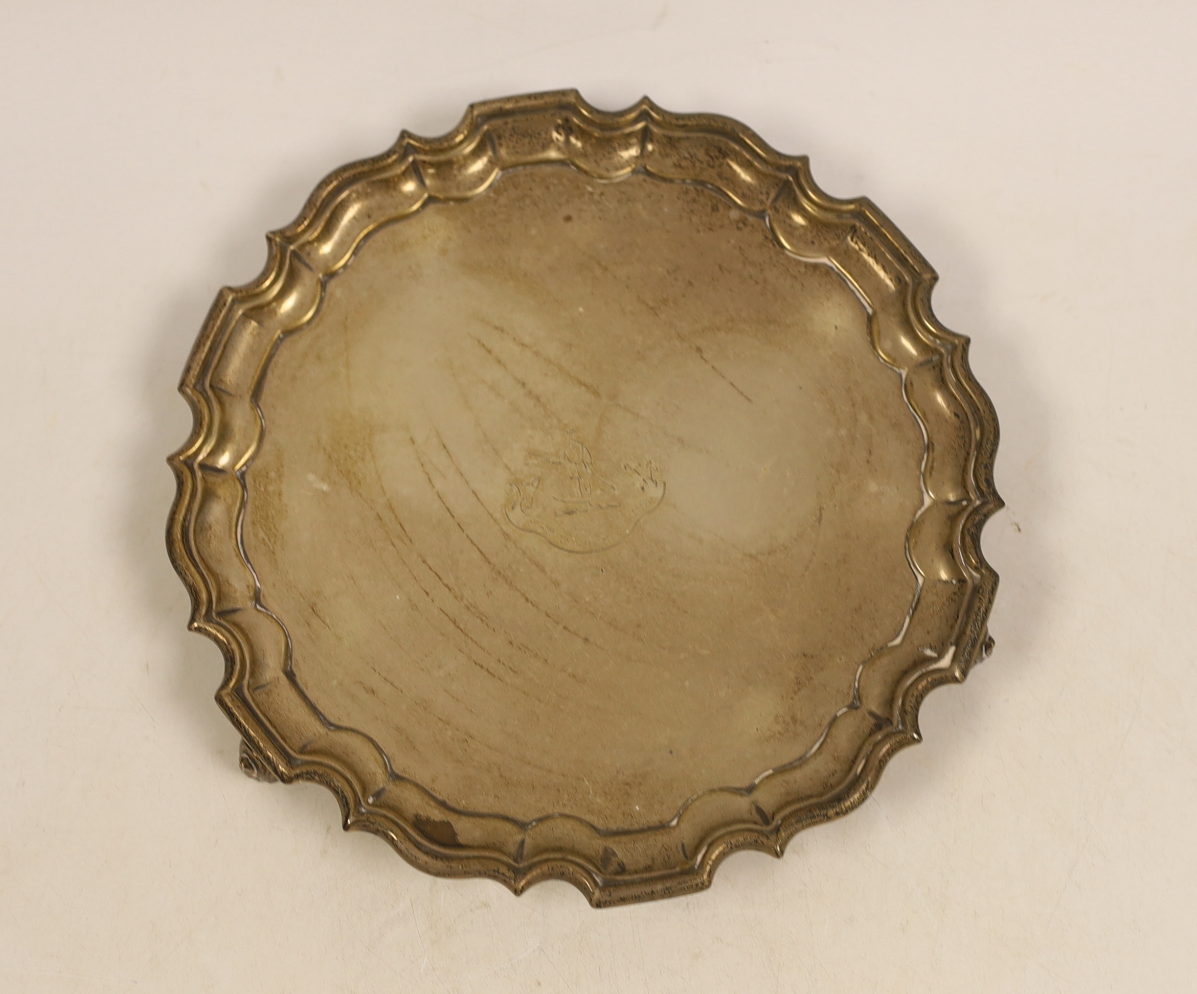 An Edwardian circular silver salver with piecrust border on three scroll feet, engraved Pilkington family crest, 